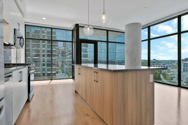 a kitchen with stainless steel appliances granite countertop a refrigerator a stove and a wooden floors