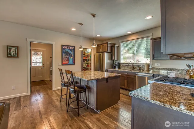 a kitchen with stainless steel appliances granite countertop sink stove top oven and cabinets