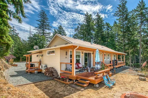 a view of house with yard and sitting area