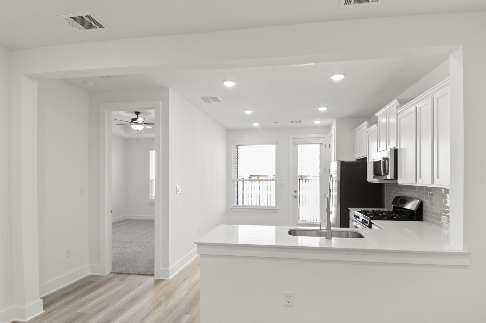 18909 Schultz Lane, Unit 1002 Round Rock, TX 78664 - Photo 11 of 24 Kitchen with light stone countertops, white cabinetry, stainless steel appliances, light wood-style flooring, and recessed lighting