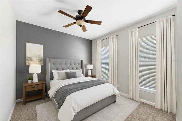 a bedroom with a large bed and a ceiling fan