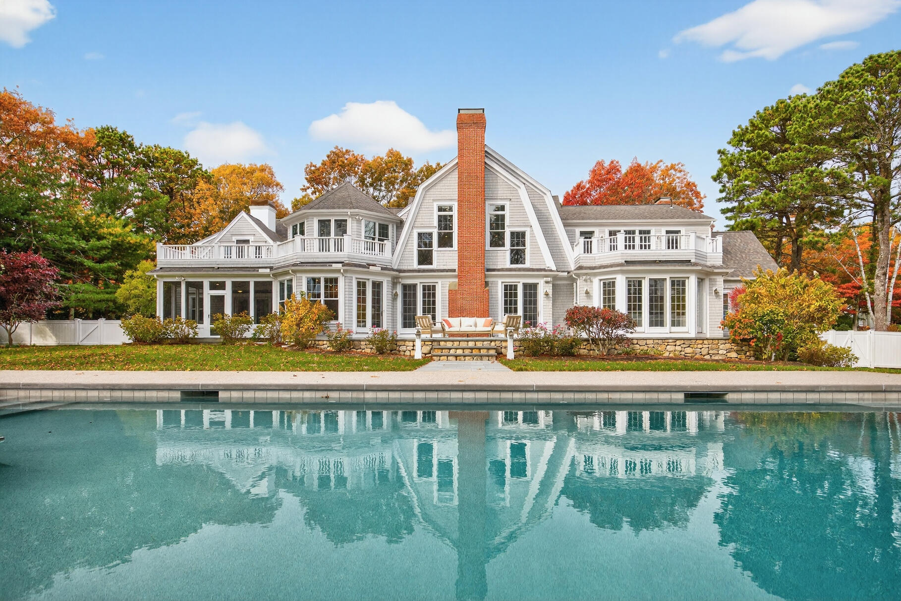 405 Bridge Street Osterville, MA 02655 - Photo 4 of 57 a front view of a house with swimming pool having outdoor seating