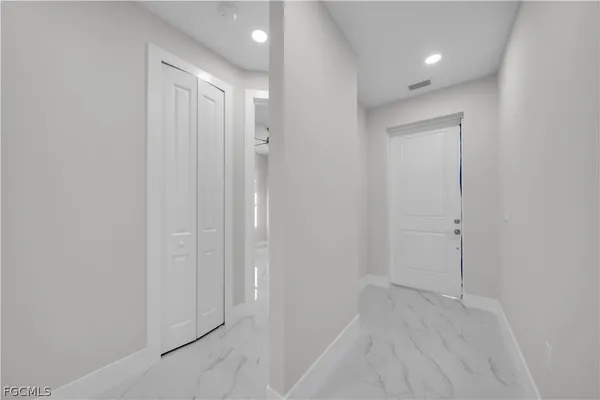 an empty room with closet and a chandelier fan