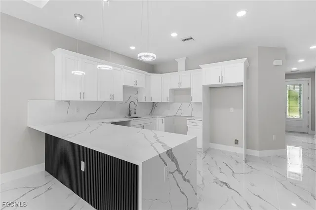 a large kitchen with kitchen island a sink stainless steel appliances and cabinets