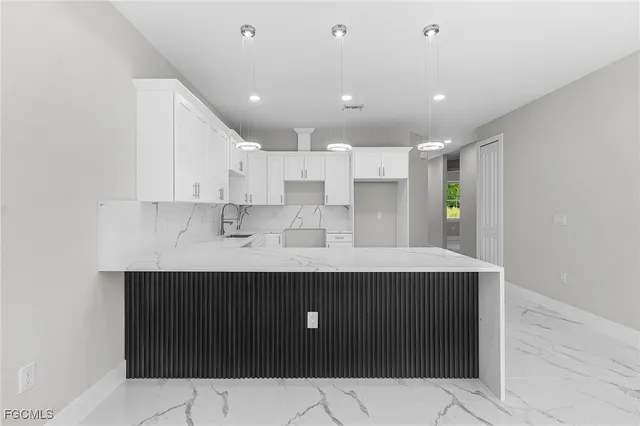 a view of kitchen with stainless steel appliances kitchen island sink refrigerator and cabinets