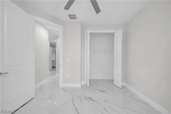 en empty room with windows and fan