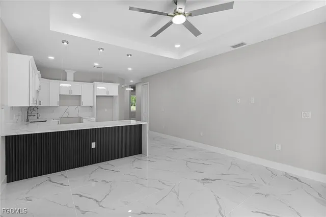 an empty room with a ceiling fan and carpet