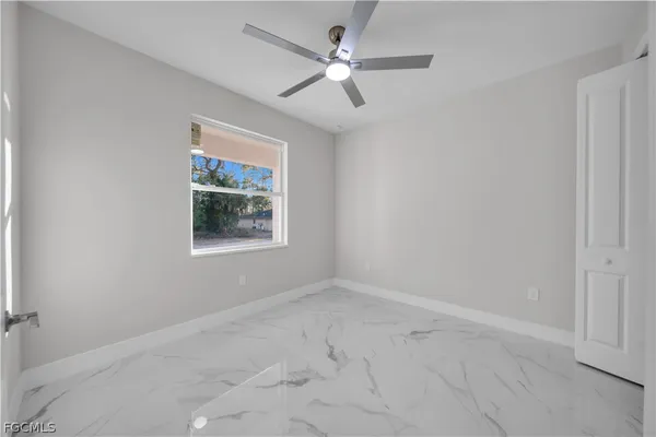 an empty room with windows and fan