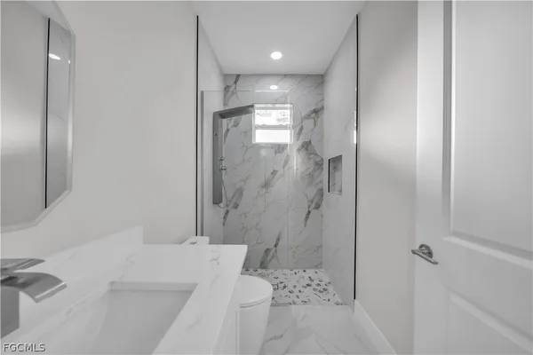 a hallway with a sink a microwave and cabinets