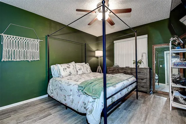 a bedroom with a bed chandelier and a window