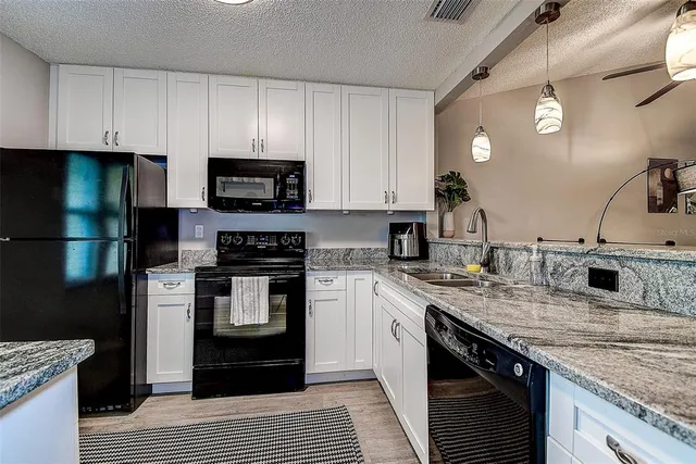 a kitchen with stainless steel appliances granite countertop a stove a sink and a refrigerator