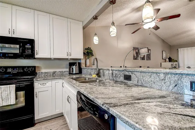 a kitchen with kitchen island granite countertop a stove sink and microwave