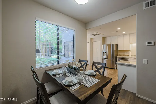 a view of a dining room and livingroom with furniture window and wooden floor