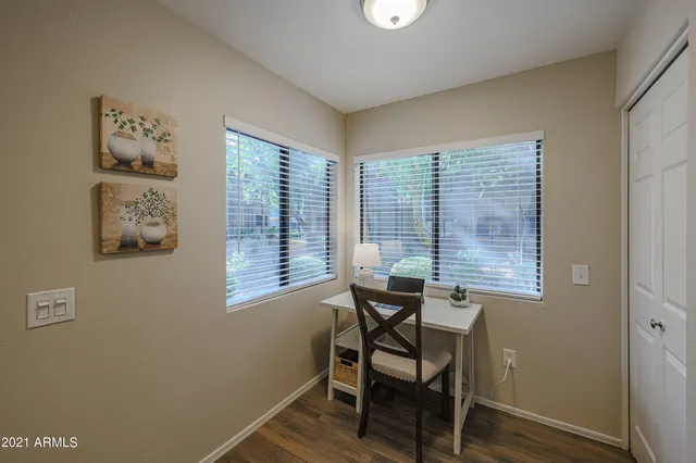 a view of a workspace with furniture and a window