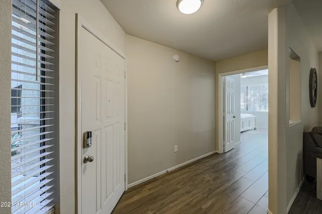 a view of a hallway with wooden floor and a bathroom