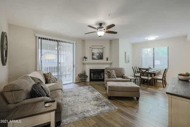 a living room with furniture a fireplace and a large window
