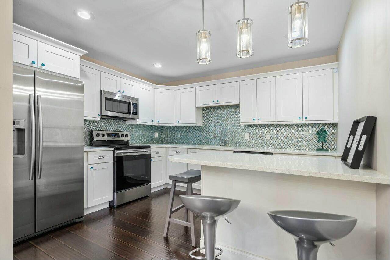 905 Northwest 29th Avenue, Unit D Delray Beach, FL 33445 - Photo 1 of 38 a kitchen with a refrigerator and a stove top oven