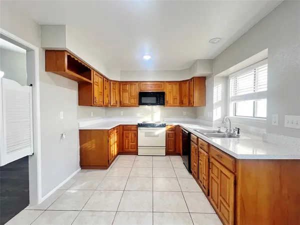 a large kitchen with stainless steel appliances granite countertop a sink and cabinets