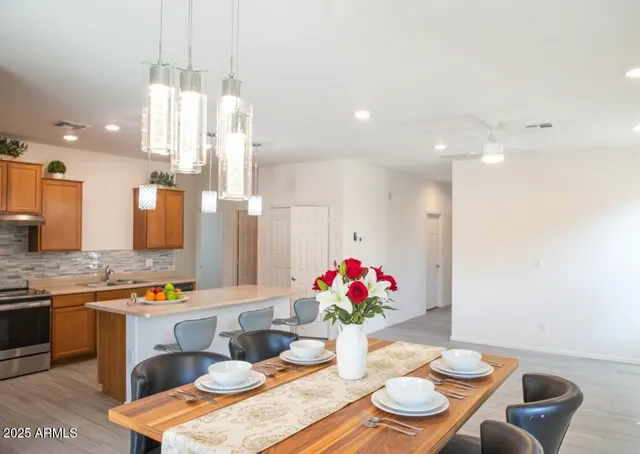 a dining room with furniture a chandelier and kitchen view
