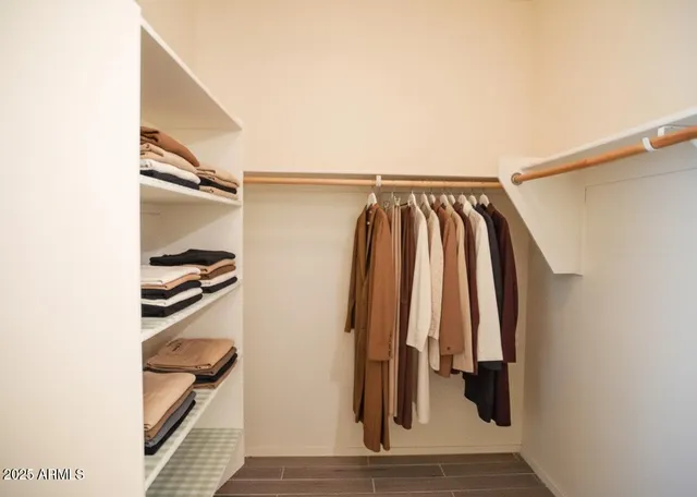 a view of walk in closet with clothes and shoes
