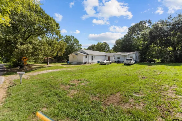 a view of house with garden and trees