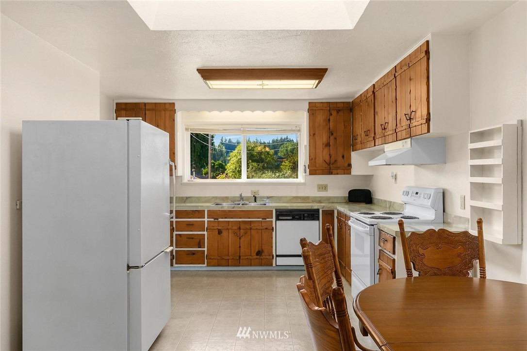1617 Ludwig Road Snohomish, WA 98290 - Photo 9 of 31 a kitchen with stainless steel appliances granite countertop a refrigerator a stove a sink dishwasher and white cabinets with wooden floor