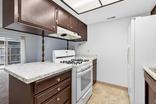 a kitchen with stainless steel appliances kitchen island granite countertop a sink and cabinets