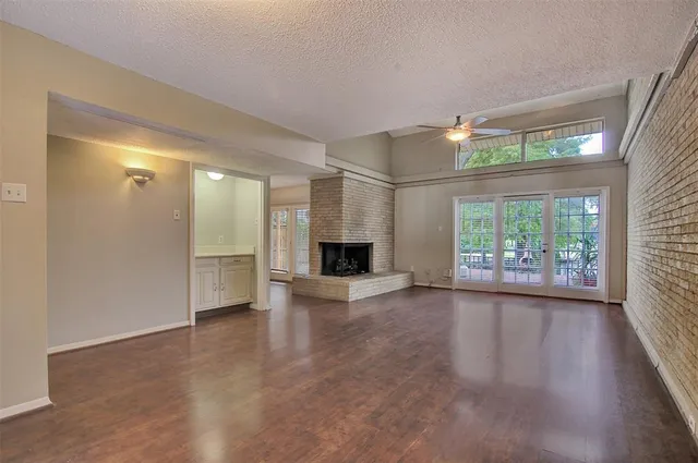 an empty room with windows and fireplace