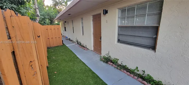 a view of a house with a yard and wooden fence