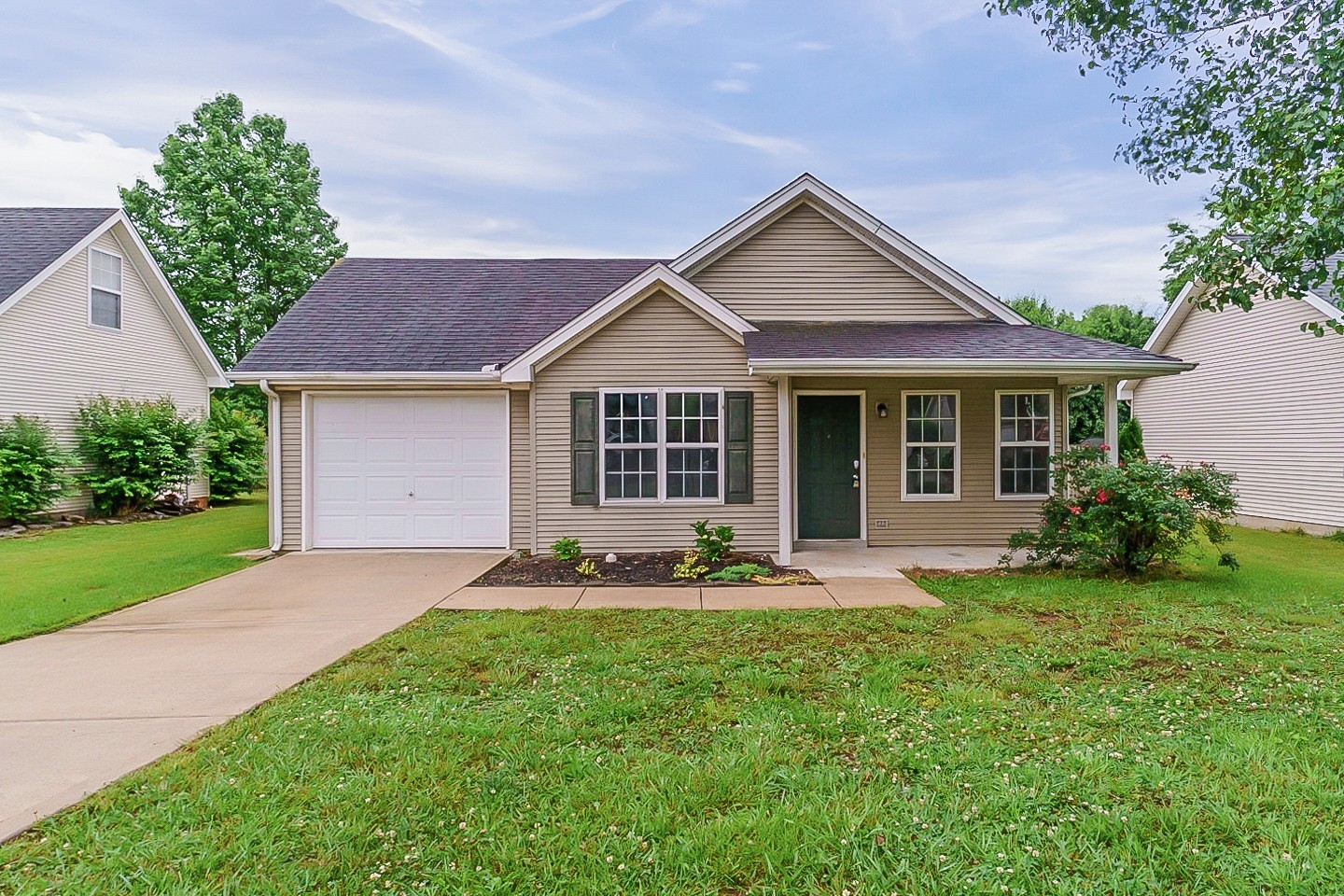 a front view of a house with a garden and yard
