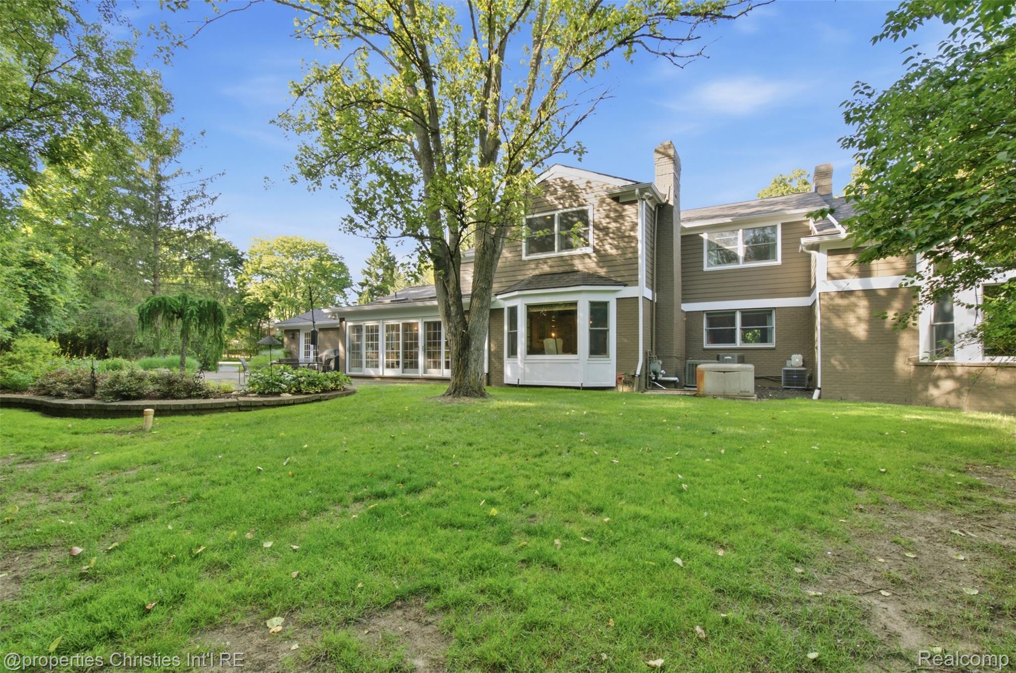 25235 Canterbury Road Franklin, MI 48025 - Photo 40 of 56 Expansive rear yard featuring a verdant lawn, mature trees, and a raised garden bed
