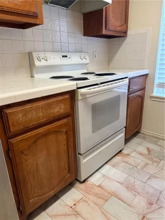 a kitchen with granite countertop white cabinets and white appliances