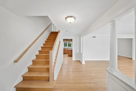 a view of an entryway with wooden floor and stairs