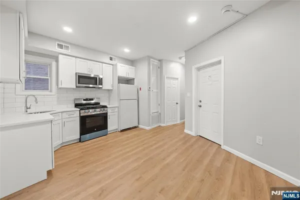 a kitchen with kitchen island a sink stainless steel appliances and cabinets