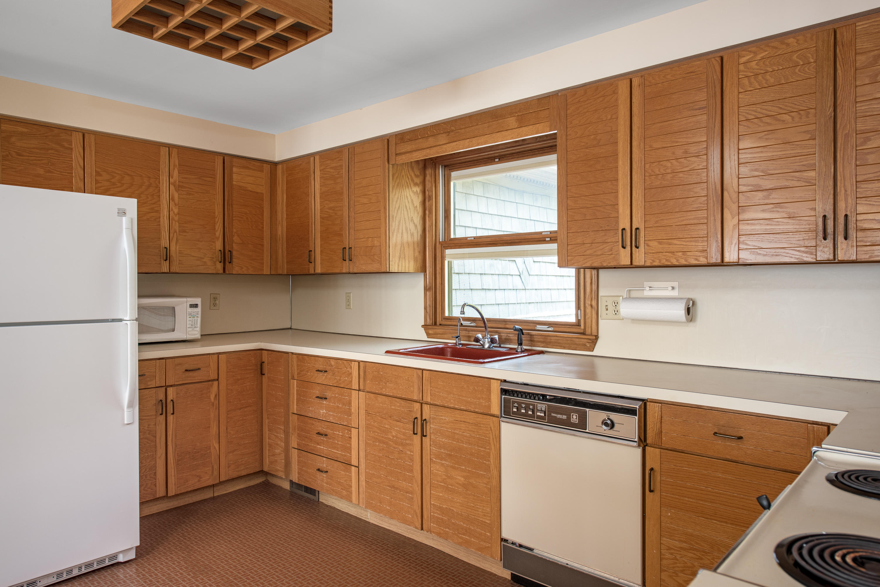 326 Holly Point Road Centerville, MA 02632 - Photo 3 of 30 a kitchen with a sink cabinets and window