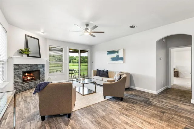 a living room with couches fireplace and a window