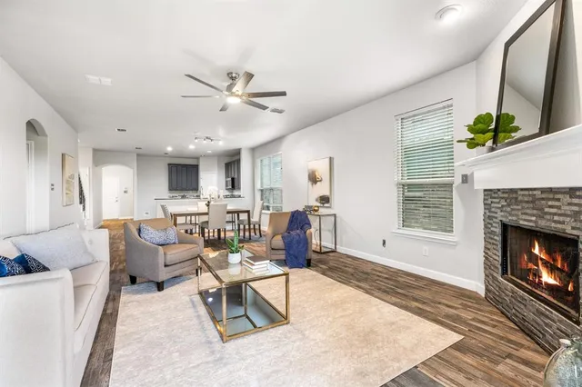 a living room with furniture a fireplace and a large window