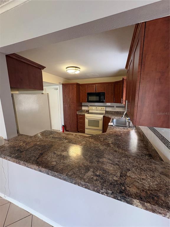 4027 Bianca Street Sebring, FL 33872 - Photo 11 of 22 a kitchen with kitchen island a stove a sink and a refrigerator