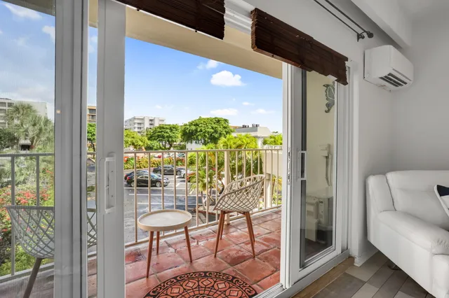 a view of a balcony with chairs and front door