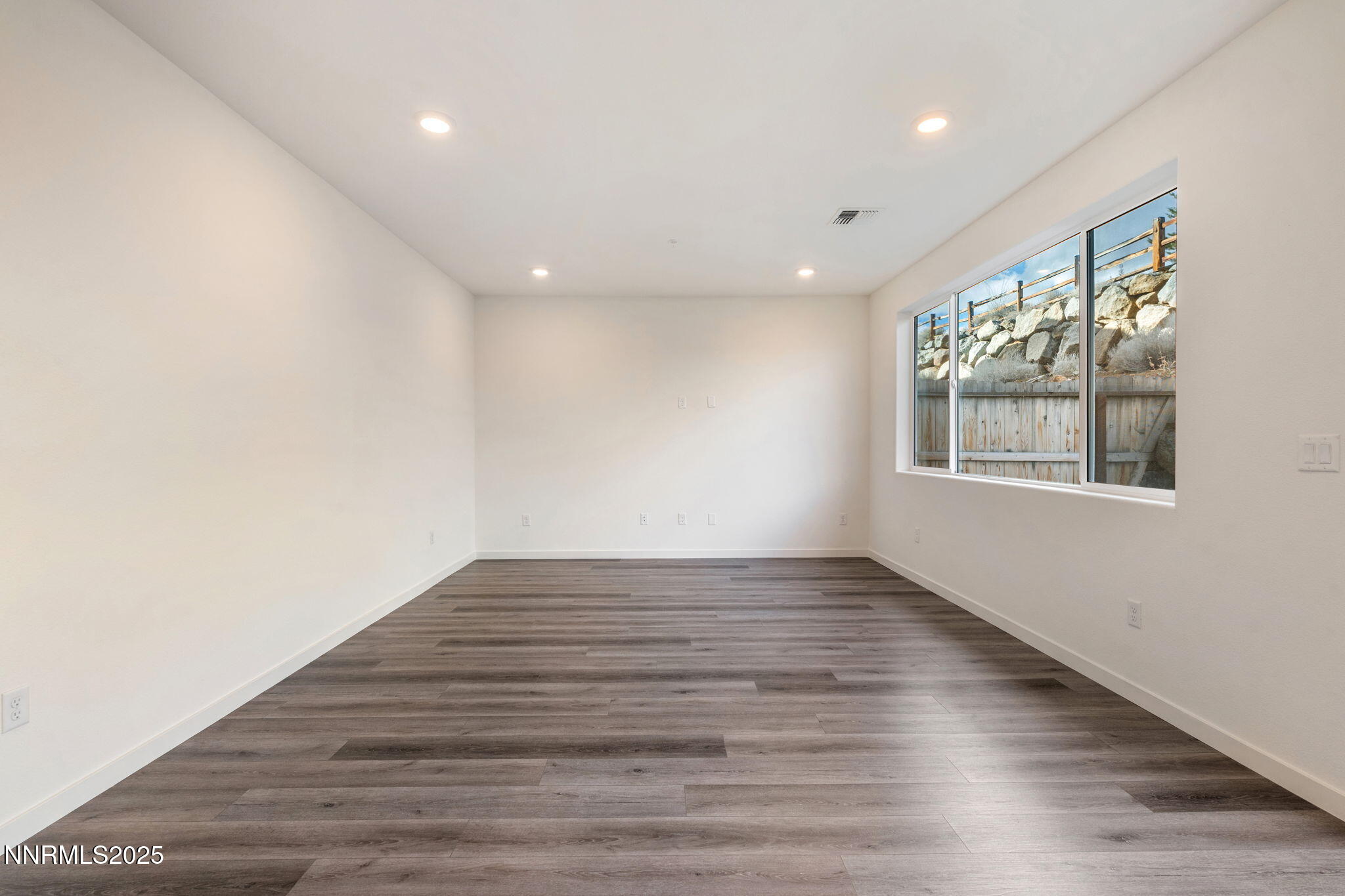 4589 Falcon Rock Lane Sun Valley, NV 89433 - Photo 16 of 26 an empty room with wooden floor and windows
