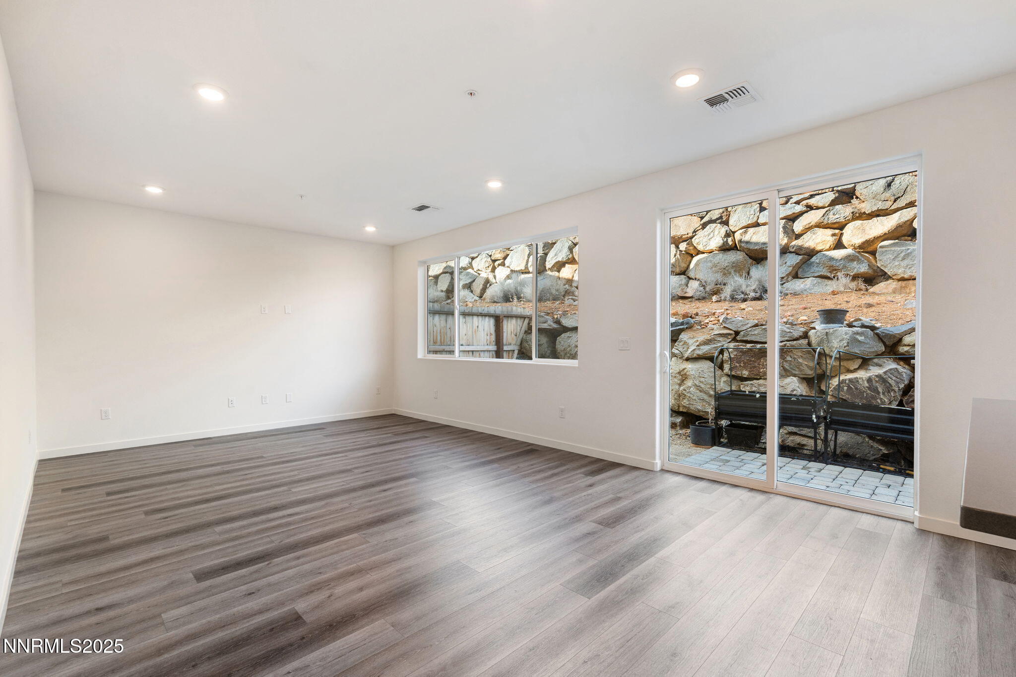 4589 Falcon Rock Lane Sun Valley, NV 89433 - Photo 17 of 26 an empty room with wooden floor and windows