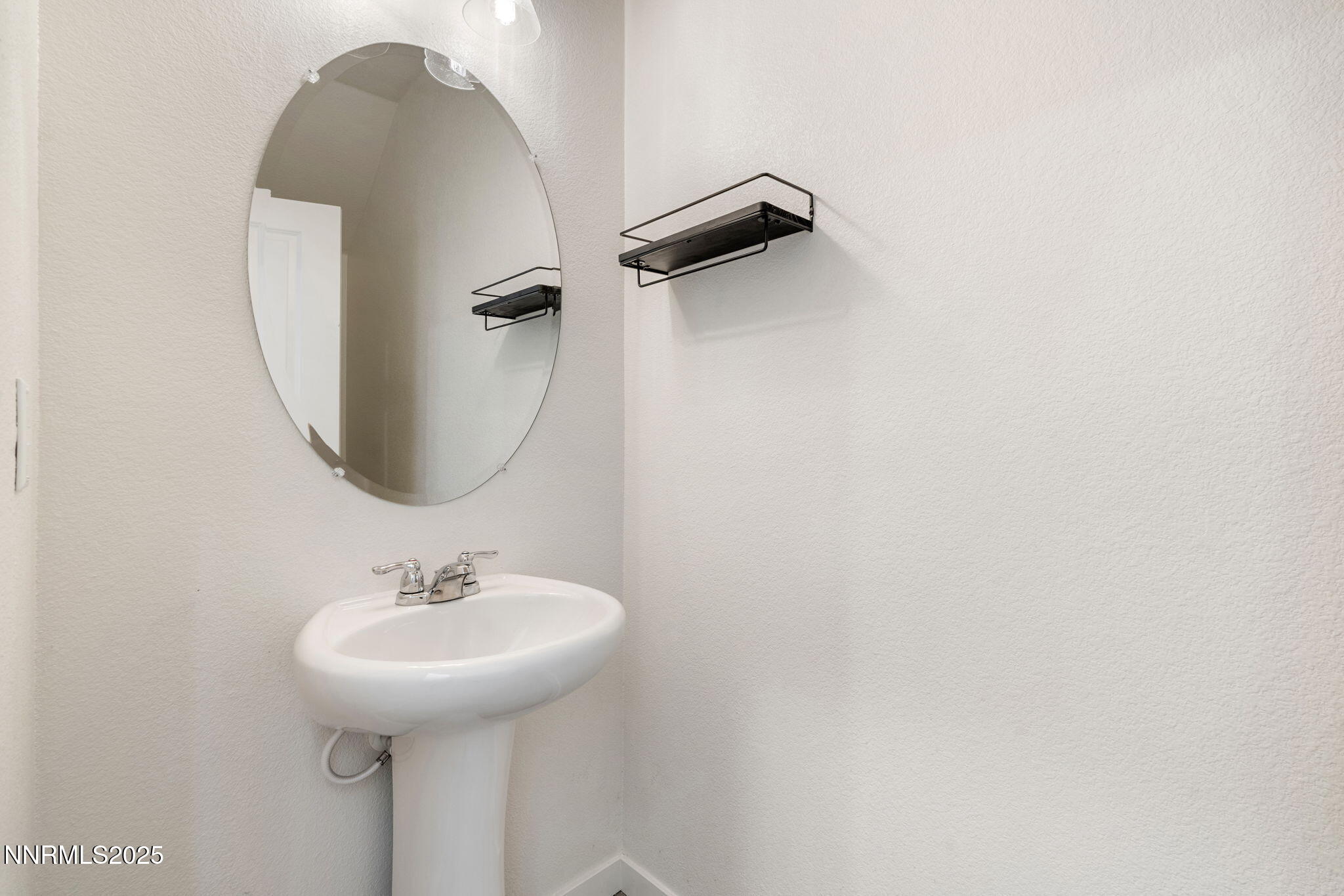 4589 Falcon Rock Lane Sun Valley, NV 89433 - Photo 6 of 26 a bathroom with a sink and a mirror