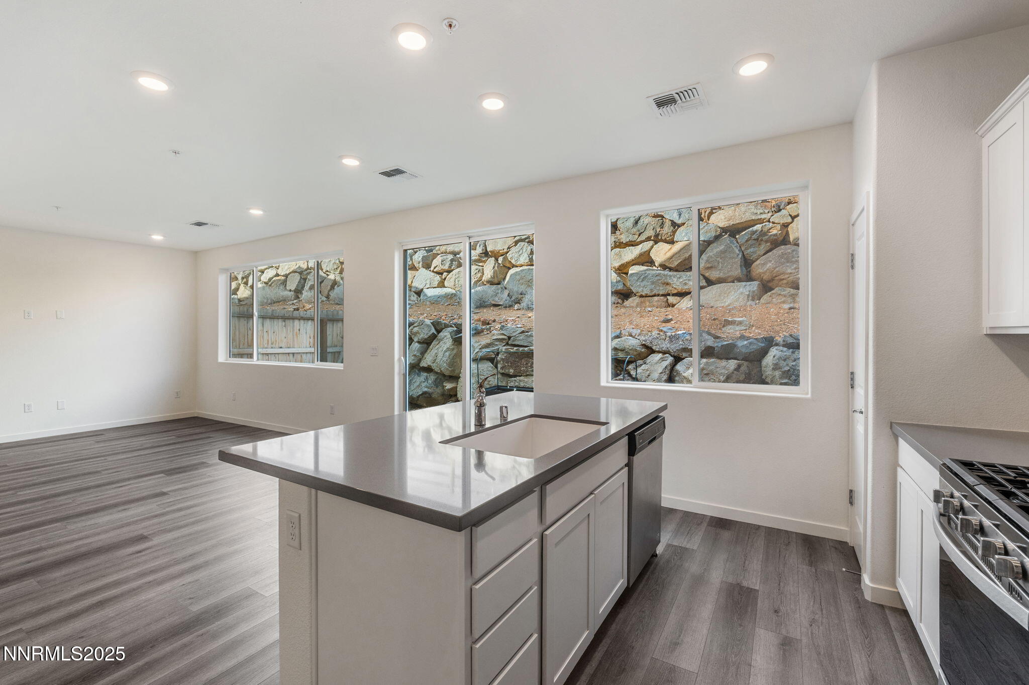 4589 Falcon Rock Lane Sun Valley, NV 89433 - Photo 8 of 26 a large white kitchen with sink and wooden floor