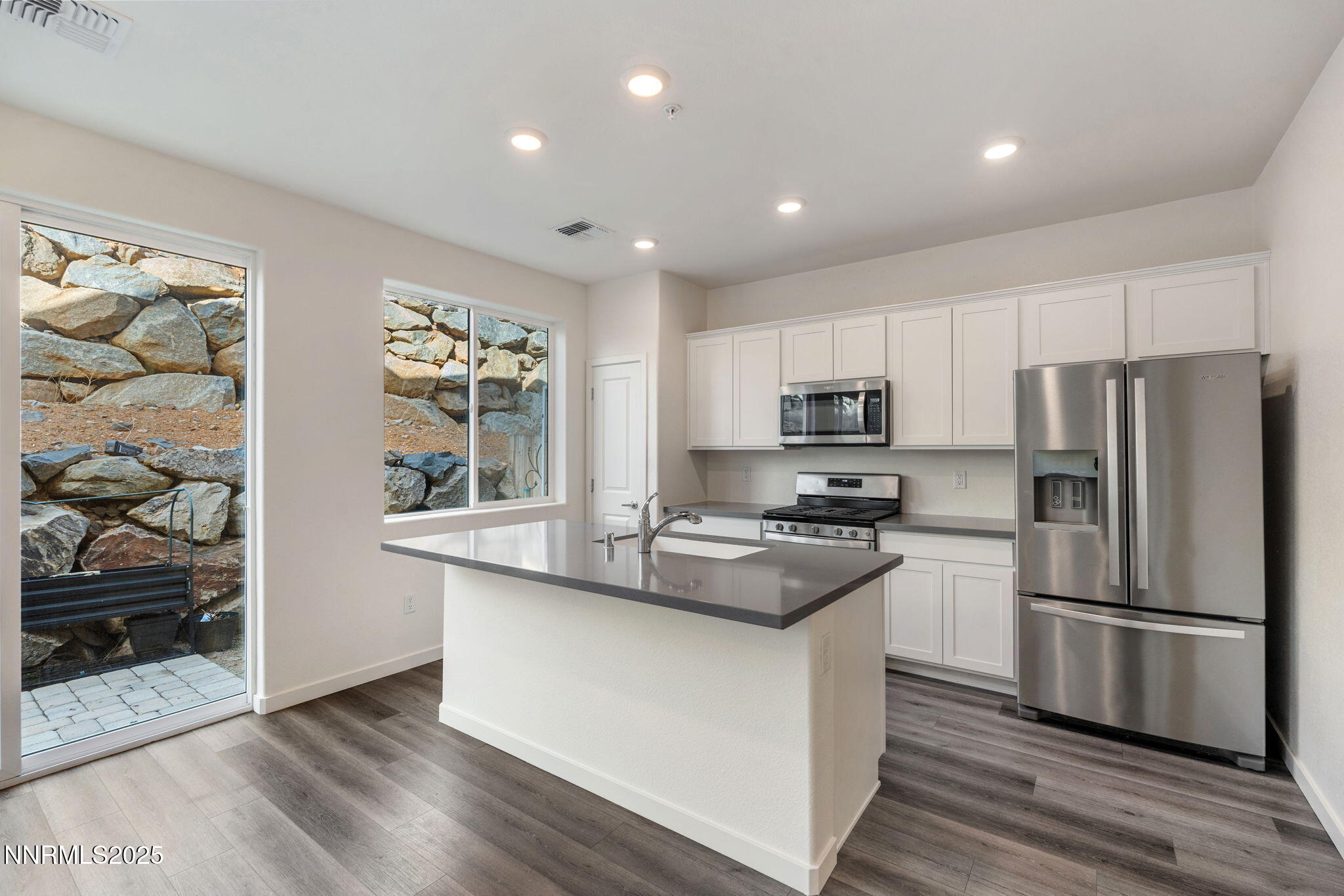 4589 Falcon Rock Lane Sun Valley, NV 89433 - Photo 9 of 26 a kitchen with stainless steel appliances granite countertop a refrigerator a stove a sink and a microwave