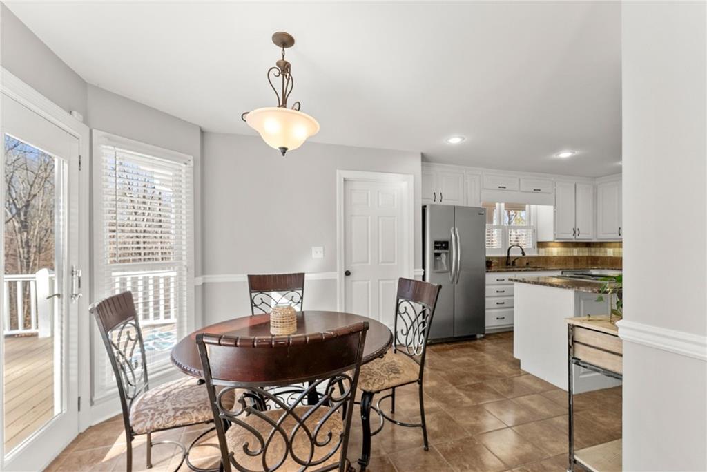 3523 Lighthouse Lane Gainesville, GA 30504 - Photo 22 of 72 a kitchen with stainless steel appliances kitchen island granite countertop a dining table chairs and granite counter tops