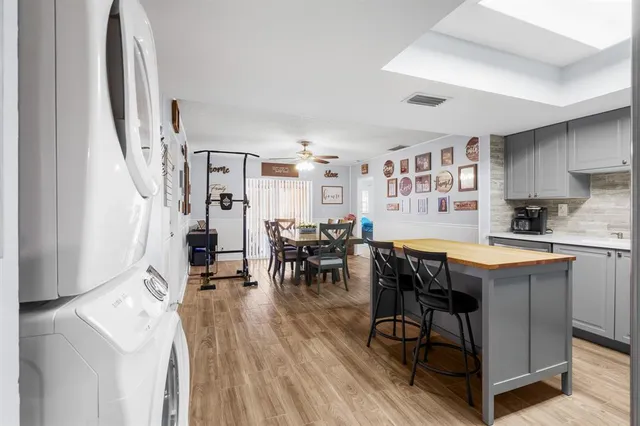 a room with stainless steel appliances kitchen island granite countertop furniture and a dining table