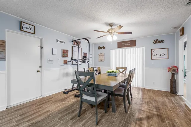 a view of a dining room with furniture and a chandelier fan