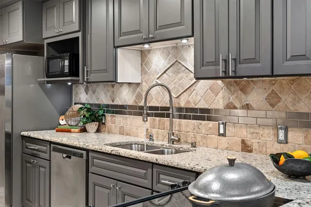 a kitchen with granite countertop a sink and cabinets