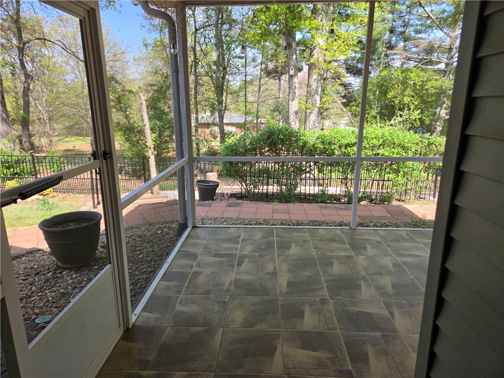 304 Knoll View Drive Seneca, SC 29678 - Photo 26 of 36 This screened patio offers serene outdoor living, with tiled flooring and views of mature trees and landscaping.