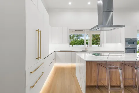 a view of a kitchen with kitchen island granite countertop a sink and a stove top oven